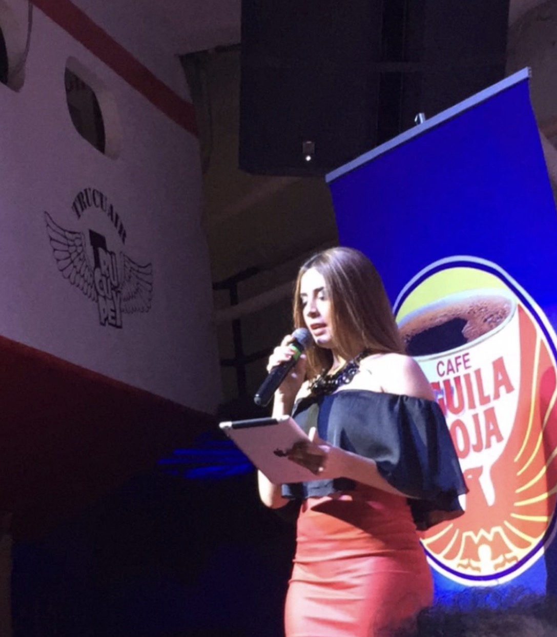 Valeria con micrófono en un ambiente de Carnaval