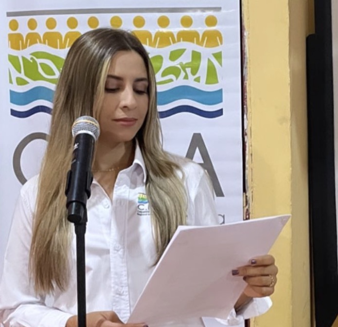 Valeria con libreto y micrófono durante un evento